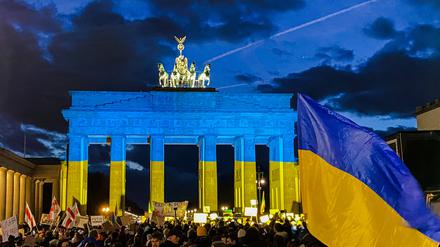 Demonstration vor dem angestrahlten Brandenburger Tor anlässlich der Kriegserklärung von Putin an die Ukraine.