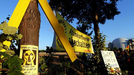 Ein Banner mit der Aufschrift "Atomkraftwerke abschalten" hängt zwischen Bäumen vor dem Atomkraftwerk Grohnde in Emmerthal.