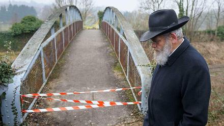 Ein Mann steht vor dem gesperrten Zugang zum jüdischen Friedhof in Sarre-Union in Frankreich, auf dem mehr als hundert Gräber geschändet worden waren. 