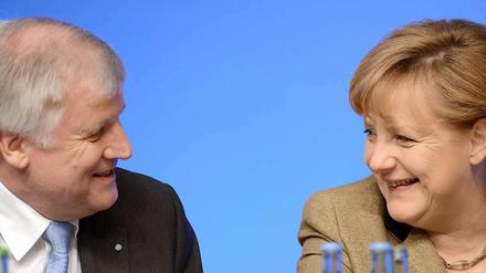 Angela Merkel und Horst Seehofer lächeln sich beim Bundesparteitag im Dezember 2012 auf dem Podium an.