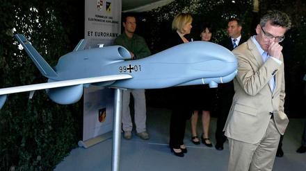 Thomas de Maizière und ein Modell der Euro-Hawk-Drohne.