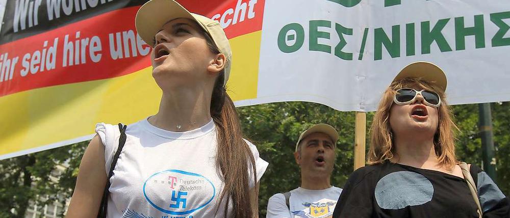 In Athen lassen sich junge Telekom-Arbeitnehmerinnen mit Hakenkreuz-T-Shirts und antideutschen Slogans ablichten.