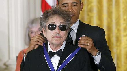 Wie eine Katze, der der Kopf gewaschen wird: Ein weniger widerwillig schien Bob Dylan sich von Barack Obama die "Medal of Freedom" umlegen zu lassen.
