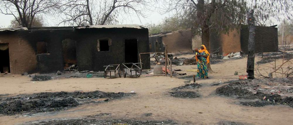 Eine Frau geht durch die Ruinen des umkämpften Ortes Baga im Nordosten von Nigeria. Das Foto ist ein Archivbild von 2013, doch am Wochenende wütete die islamistische Sekte Boko Haram erneut in Baga und Umgebung. Der Ort soll niedergebrannt sein, berichten Augenzeugen.