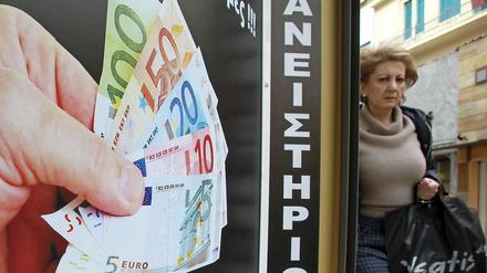 Noch bekommen Verzweifelte Euro für ihre Familienerbstücke: Eine Frau geht in Athen an einem Pfandleihgeschäft vorbei.