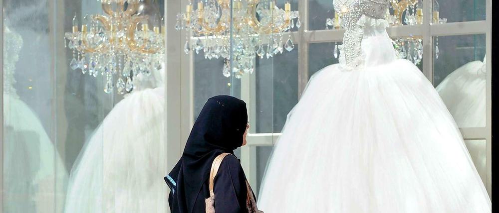 Zwischen Tradition und Moderne: Eine Frau betrachtet in der saudi-arabischen Hauptstadt Rijad ein Schaufenster mit Brautmoden