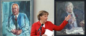 Bundeskanzlerin Angela Merkel (CDU) im Bundeskanzleramt in Berlin zwischen den Gemälden ihrer Amtsvorgänger Helmut Kohl (CDU, l) und Helmut Schmidt (SPD).