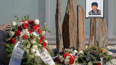 Trauernde haben Blumenkränze und ein Bild des getöteten Jonny K. zu dessen Trauerfeier hinterlegt. 