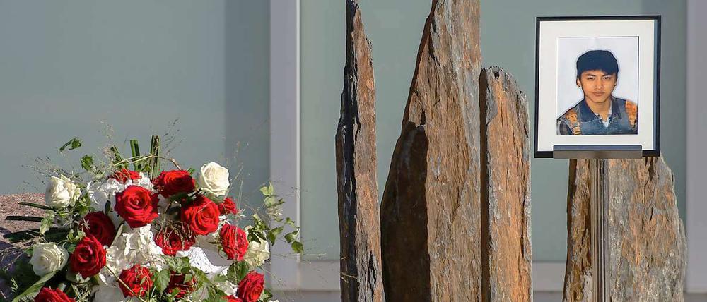Trauernde haben Blumenkränze und ein Bild des getöteten Jonny K. zu dessen Trauerfeier hinterlegt. 