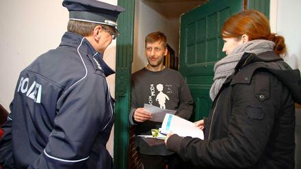 Ein Polizeibeamter und eine Polizeischülerin informieren einen Anwohner in Prenzlauer Berg, wie er seine Wohnung einbruchsicher machen kann.