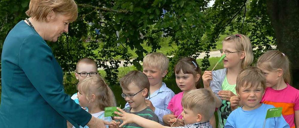 Bundeskanzlerin Angela Merkel wird am 31.05.2013 in der SOS-Dorfgemeinschaft Grimmen (Mecklenburg-Vorpommern) von Kita-Kindern zum SOS-Jahresempfang begrüßt. 