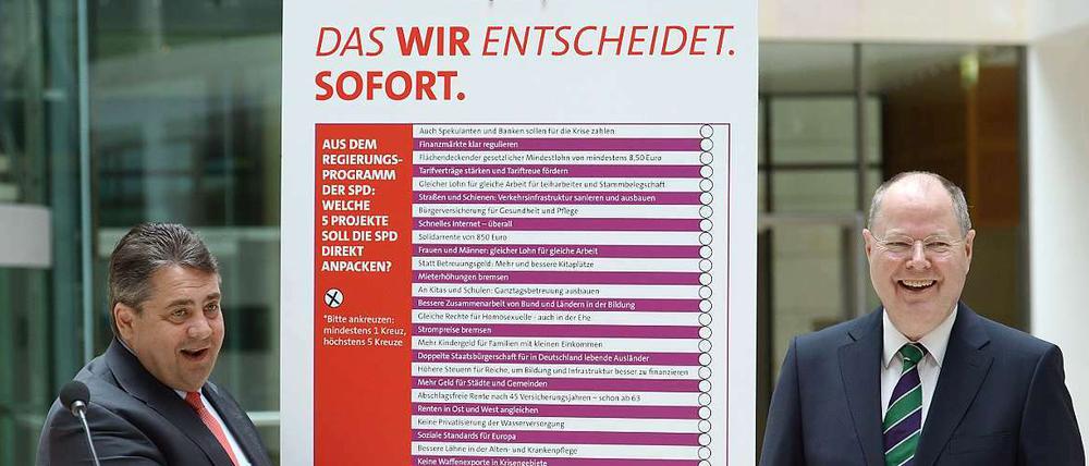 SPD-Parteichef Sigmar Gabriel und SPD-Kanzlerkandidat Peer Steinbrück stellen eine Mitmach-Aktion vor. Auf dem präsentierten Plakat, das die beiden präsentieren, steht "Das Wir entscheidet. Sofort."