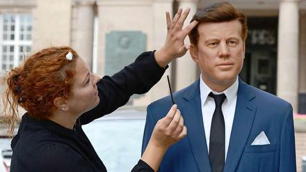 Eine Mitarbeiterin des Wachsfigurenkabinetts Tussauds legt letzte Hand an eine Kennedy-Figur, die zum Jahrestag seiner Rede zum Fototermin vor das Schöneberger Rathaus gebracht wurde.