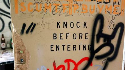 Das Foto zeigt ein Graffiti auf einer Tür an der ehemaligen Abhörstation der NSA auf dem Teufelsberg in Berlin. Der Text lautet: Knock before entering.
