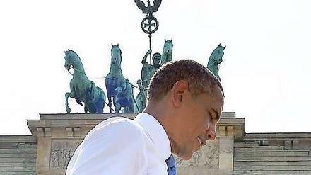 Das Bild zeigt US-Präsident Barack Obama vor dem Brandenburger Tor, ohne Jackett und mit leicht gequältem Gesichtsausdruck.