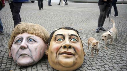 Masken von Angela Merkel und Sigmar Gabriel vor dem Bundestag bei einer Protestaktion.
