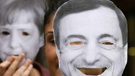 Demonstranten in Italien mit Masken von Angela Merkel und Mario Draghi. 