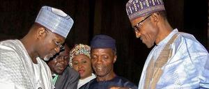 Der künftige Präsident Muhammadu Buhari (rechts) nimmt die Wahlergebnisse vom Chef der unabhängigen Wahlkommission Attahiru Jega (links) entgegen. In der Mitte steht der künftige Vizepräsident Yemi Osinbajo und im Hintergrund Buharis Ehefrau Aischa. 