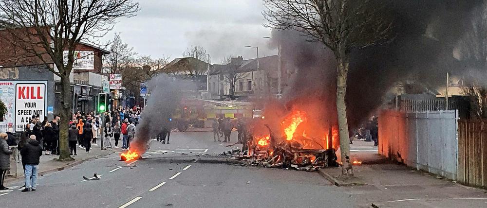 Ein Bus brennt in der Shankill Road in West Belfast. Loyalisten, also Anhänger des Verbleibs von Nordirland im Vereinigten Königreich, hatten den Bus entwendet und angezündet. 