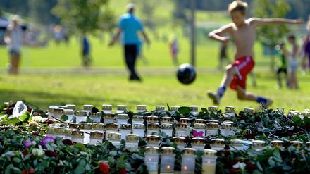 Das Leben muss weitergehen. Kinder spielen auf einer Wiese neben einer Trauerstätte für die 77 Opfer der Anschläge in Norwegen.