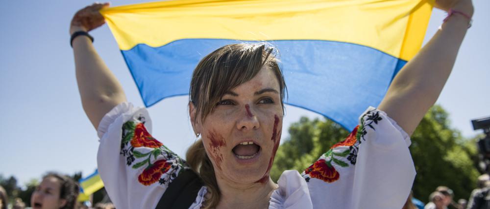 Die Solidarität mit der Ukraine ist riesig in Polen.  Eine Demonstrantin hält eine ukrainische Flagge hoch. 