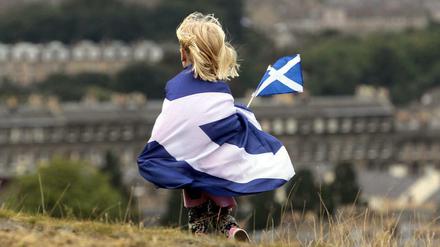 Ein Mädchen umhüllt von der schottischen Flagge. Am 18. September stimmen die Schotten über ihre Unabhängigkeit von Großbritannien ab.