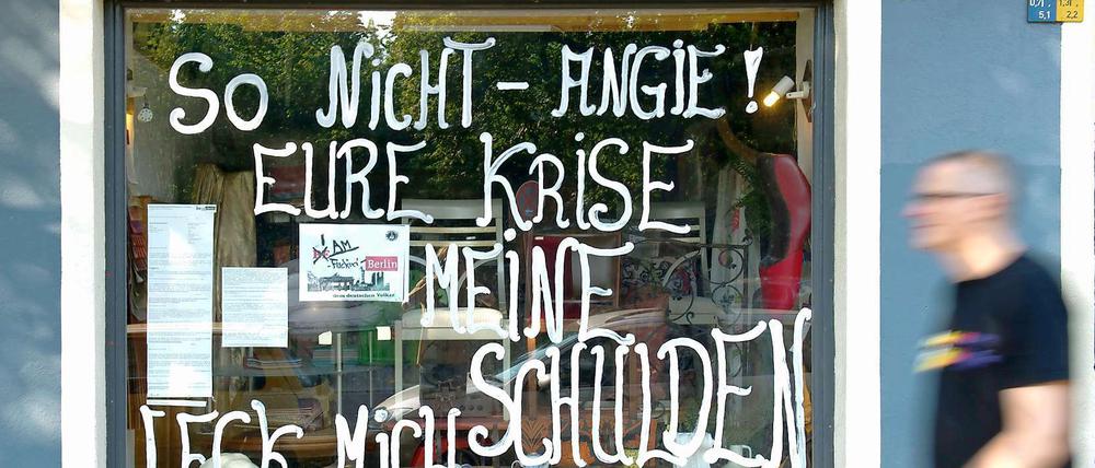 "So nicht Angie! Eure Krise - meine Schulden", steht auf einem Schaufenster in Berlin.