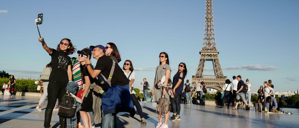 Wir und die Welt. Touristinnen vor dem Pariser Eiffelturm.