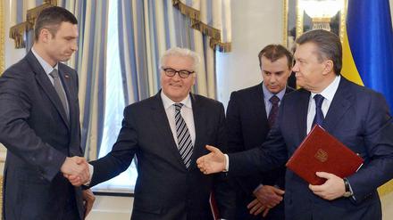 Der deutsche Außenminister Frank-Walter Steinmeier (mitte) Ende Februar 2014 in der Ukraine mit den politischen Gegnern Vitali Klitschko (l.) und Viktor Janukowitsch.