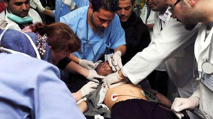 Auch am zweiten Jahrestag setzten sich die Kämpfe um Damaskus fort. Ärzte versorgen einen Verwundeten.