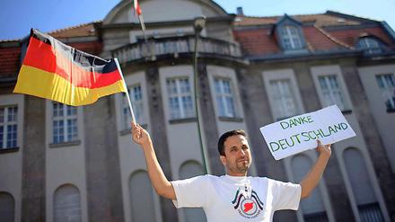 Vor der syrischen Botschaft in Berlin hält ein Demonstrant ein Schild mit der Aufschrift "Danke Deutschland" in die Höhe. Deutschland, die USA und mehrere andere Länder wiesen am Dienstag in Reaktion auf das Massaker von Hula die syrischen Botschafter aus.