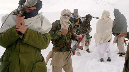 Taliban-Kämpfer in Afghanistan lassen sich vermummt und schwer bewaffnet ablichten.