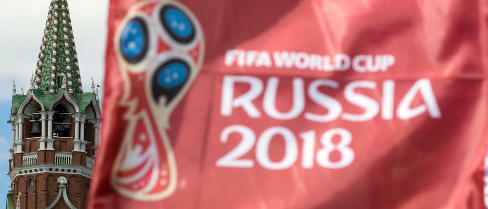 Eine Flagge mit dem Logo der Fußball WM 2018 weht auf dem Roten Platz vor dem Spasski-Turm des Moskauer Kreml. 