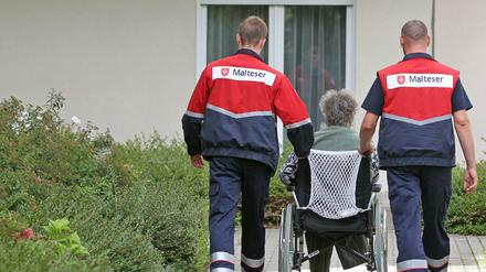 Zwei Zivildienstleistende kümmern sich um eine Dialysepatientin im Rollstuhl, aufgenommen am 24.08.2010 in Leipzig - ein Jahr später wurde der Zivildienst abgeschafft.