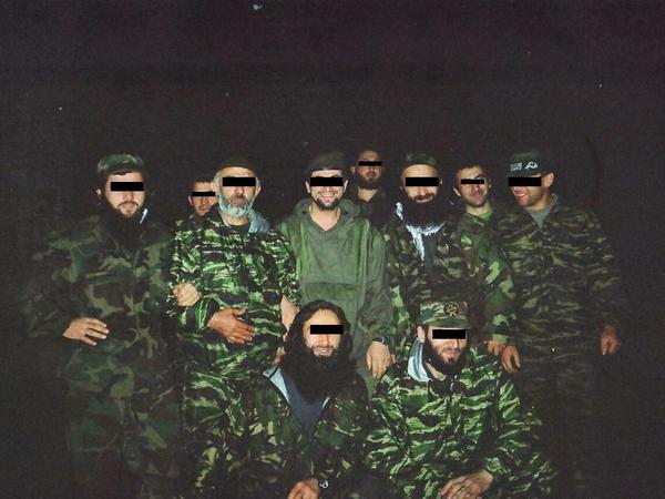 K. im Kreise der Feldkommandeure der Rebellen im Zweiten Tschetschenienkrieg. K. ist ganz links zu sehen. Er hakt sich bei Rebellenführer Aslan Maschadow unter. 