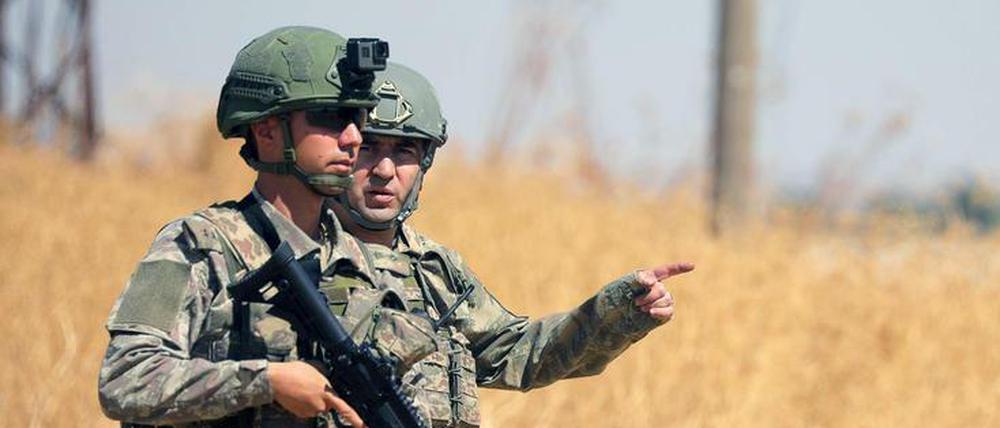 Türkischer und amerikanischer Soldat wachen an der Grenze zur syrischen Kurdenregion.