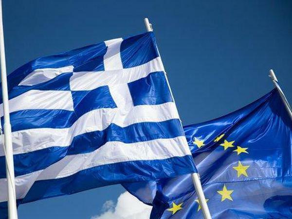 Die griechische Flagge weht zwischen zwei Europaflaggen.