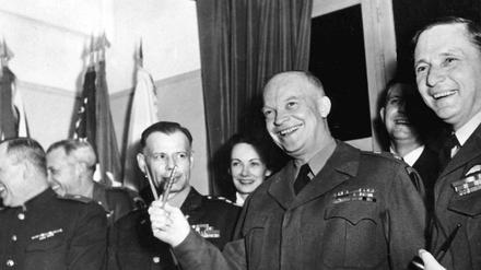 General Dwight D. Eisenhower hält die zwei Stifte, mit denen die bedingungslose Kapitulation der Wehrmacht am 7. Mai in Reims unterzeichnet wurde, in Anlehnung an das Victory-Zeichen wie ein «V». 