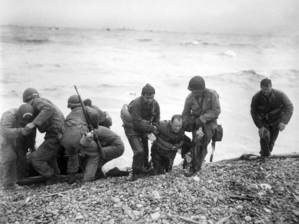 Soldaten einer amerikanischen Landeeinheit helfen ihren Kameraden während der Landung der alliierten Truppen an Land. (Archivbild 06.06.1944)