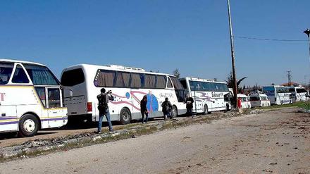 Die ersten Bewohner der syrischen Stadt Homs verlassen in Bussen und Krankenwagen ihre Heimat.