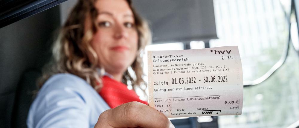Eine Hamburger Busfahrerin präsentiert ein 9-Euro-Ticket des HVV. 