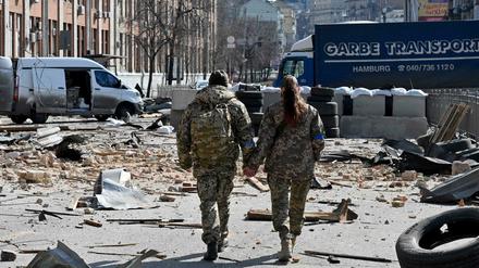 Zwei ukrainische Soldaten laufen Hand in Hand durch Kiew.