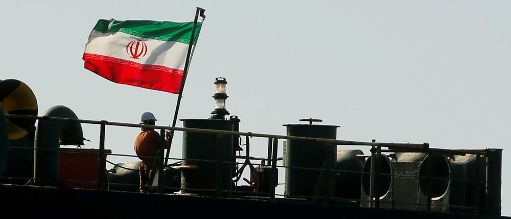Ein Crewmitglied hisst die iranische Flagge auf der Adrian Darya 1.
