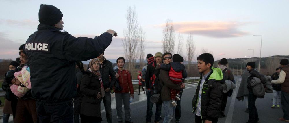 Ein griechischer Polizist stoppt afghanische Migranten auf dem Weg zur mazedonischen Grenze. 