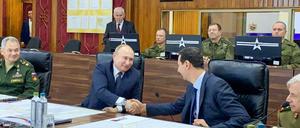 Putin (l) und Assad schütteln sich am Sitz der russischen Streitkräfte in Damaskus die Hände. 