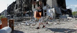 Ein Mann rettet Möbel aus einem zerstörten Haus in Mariupol.