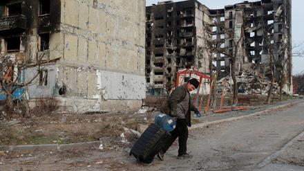 Ein Bewohner läuft durch ein zerstörtes Wohnviertel in der Hafenstadt Mariupol.