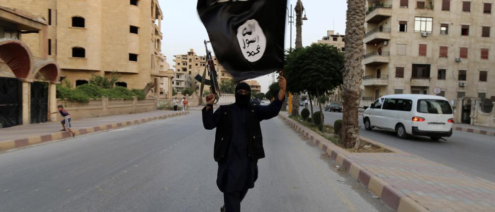 A member loyal to the Islamic State in Iraq and the Levant (ISIL) waves an ISIL flag in Raqqa June 29, 2014. The offshoot of al Qaeda which has captured swathes of territory in Iraq and Syria has declared itself an Islamic "Caliphate" and called on factions worldwide to pledge their allegiance, a statement posted on jihadist websites said on Sunday. The group, previously known as the Islamic State in Iraq and the Levant (ISIL), also known as ISIS, has renamed itself "Islamic State" and proclaimed its leader Abu Bakr al-Baghadi as "Caliph" - the head of the state, the statement said. REUTERS/Stringer (SYRIA - Tags: POLITICS CIVIL UNREST TPX IMAGES OF THE DAY) FOR BEST QUALITY IMAGE ALSO SEE: GF2EAAO0VU501 - RTR3WBPT