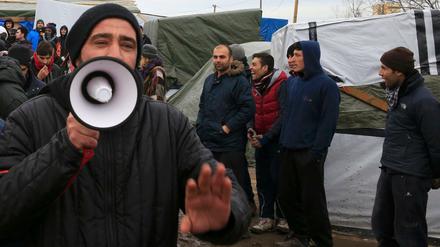 Flüchtlinge protestierten, als eine Richterin am Dienstag den "Dschungel" in Calais besuchte.