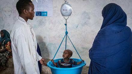 Was ein junges Leben wiegt. Ein somalischer Ernährungsexperte kontrolliert das Gewicht eines Kindes.